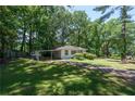 Beautiful shot of a single-story home with mature trees and a covered carport on a sunny day at 1920 W Forrest Ave, Atlanta, GA 30344