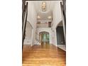Bright and airy foyer with hardwood floors, high ceilings, elegant light fixture, and an open staircase at 915 Summer Wind Pl, Roswell, GA 30075