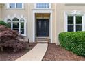 Elegant front entrance featuring a double door entry, stone walkway, and landscaped garden beds at 915 Summer Wind Pl, Roswell, GA 30075