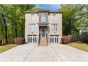 Stately brick home featuring a two-car garage, landscaped front yard and covered front porch entry at 3110 Dickson Ne St, Brookhaven, GA 30319