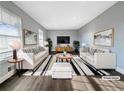 Bright and airy living room with white sofas, striped rug, and modern decor at 5211 Benjamin Trl, Ellenwood, GA 30294