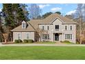 Elegant two-story home with a manicured lawn and beautiful landscaping provides a picturesque setting at 8610 Sentinae Chase Dr, Roswell, GA 30076