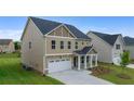 Side view of a tan two-story home with a two-car garage on a grassy lot at 13562 Whitman Ln, Covington, GA 30014