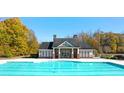 Community pool with a clubhouse surrounded by mature trees at 13562 Whitman Ln, Covington, GA 30014