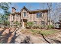 Traditional brick home with attached garage with mature trees and landscaped front yard at 24 Ball Creek Hl, Atlanta, GA 30350