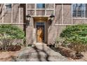 Close up of a front door framed by lamps and shrubbery leading to a brick path at 24 Ball Creek Hl, Atlanta, GA 30350