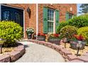 Close-up of the walkway to the front door featuring brick edging, potted plants, and decorative outdoor lighting at 308 Paper Woods Dr, Lawrenceville, GA 30046