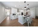 Well-lit kitchen with white cabinets, stainless steel appliances, a center island, and hardwood floors at 8The07 Stickley Oak Way, Woodstock, GA 30189