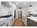 Modern kitchen with white cabinetry, stainless steel appliances, and a center island with a black faucet at 8The07 Stickley Oak Way, Woodstock, GA 30189