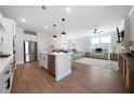 Bright open concept living space with hardwood floors, modern lighting, and a stylish kitchen island at 8The07 Stickley Oak Way, Woodstock, GA 30189