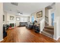 Open-concept living room featuring hardwood floors, a cozy fireplace, and staircase to upper level at 2296 Raven Cir, Lithonia, GA 30058