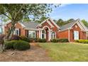 Charming red brick home with mature trees, manicured landscaping, and a well-maintained lawn at 500 Meadowmeade Ln, Lawrenceville, GA 30043
