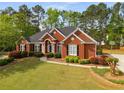 Beautiful brick home with lush green lawn, mature trees, and a basketball hoop in the driveway at 500 Meadowmeade Ln, Lawrenceville, GA 30043
