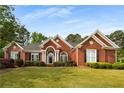 Charming red brick home with a well-manicured lawn and mature landscaping at 500 Meadowmeade Ln, Lawrenceville, GA 30043