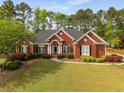 Lovely brick home with a green lawn, manicured bushes, and mature landscaping at 500 Meadowmeade Ln, Lawrenceville, GA 30043