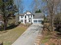 Two-story home boasting a grey roof, a long driveway and an inviting landscaped front yard at 6972 Sandtown Ln, Stone Mountain, GA 30087