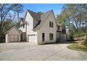 Wide exterior shot featuring a white brick two-story home with a three car garage and concrete driveway at 1074 Moores Mill Nw Rd, Atlanta, GA 30327