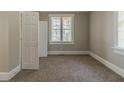 Bedroom with neutral walls and carpet, featuring a large window and a double door closet at 1124 Lawton Sw Pl, Atlanta, GA 30310