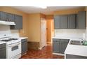 Bright kitchen showcasing grey cabinets, white countertops, and an oven range, with a glimpse into the adjacent living space at 1972 Ashwood Grove Dr, Snellville, GA 30078