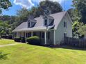 Well-maintained home with dormer windows, green lawn, and mature trees at 728 Slew Ave, Lawrenceville, GA 30043