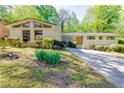 Charming single-story home with a brick facade, lush landscaping, and a long driveway at 558 Larchmont Nw Dr, Atlanta, GA 30318
