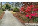 Beautiful home with a long driveway, landscaped yard, and colorful azalea bushes at 3200 W Roxboro Rd, Atlanta, GA 30324