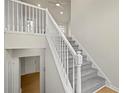 Bright, carpeted staircase with white railings and views of the foyer at 1160 Chateau Ter, Mcdonough, GA 30253