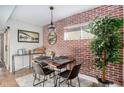 Bright dining area featuring a brick wall, contemporary light fixture, seating for four, and decorative accents at 19 Ne Rumson Ne Rd # B20, Atlanta, GA 30305
