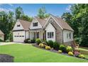 Beautiful stone and siding home with an attached garage, manicured lawn, and professional landscaping for great curb appeal at 244 Cedar Ridge Way, Dallas, GA 30157
