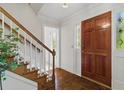 Inviting foyer with hardwood floors, a staircase with white railings, and a stylish front door at 1550 Pine Creek Way, Woodstock, GA 30188