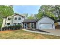 Beautifully landscaped front yard showcasing a modern two-story home, painted in a crisp white at 1960 Calvin Dr, Duluth, GA 30097