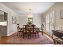 Elegant dining room featuring a wooden table, patterned rug, and bright window at 7130 Spalding Ne Ct, Atlanta, GA 30328
