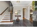 Welcoming foyer with slate floors, wooden stairs, and decorative wreath on the front door at 7130 Spalding Ne Ct, Atlanta, GA 30328