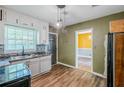 Well-lit kitchen offering white cabinets, wood flooring, and stainless steel appliances at 1239 Avonwood Sw Cir, Atlanta, GA 30311