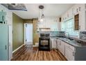 Bright kitchen with white cabinets, wood floors, a mosaic backsplash, and modern lighting at 1239 Avonwood Sw Cir, Atlanta, GA 30311