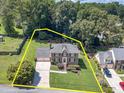 Aerial view of a brick home with a well-manicured lawn and mature trees at 4481 Lucerne Sw Pl, Lilburn, GA 30047