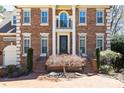 Elegant brick home with decorative columns, manicured landscaping, and a brick driveway at 4620 Chattahoochee Se Xing, Marietta, GA 30067