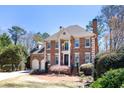 Attractive brick home boasts a manicured lawn and attached two-car garage at 4620 Chattahoochee Se Xing, Marietta, GA 30067