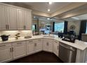 Open kitchen with marble countertops, white cabinetry, stainless steel appliances, and dark hardwood floors at 1601 Bonica Xing # 1601, Cumming, GA 30040
