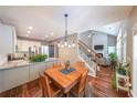 The bright dining area features an ornate light fixture and an open view of the living room and staircase at 515 Roland Manor Dr, Dacula, GA 30019