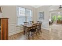 Dining area with hardwood floors, wainscotting, a window with blinds and a dark wooden table at 1098 Central Park Rd, Decatur, GA 30033