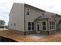 Rear view of the house featuring neutral colored siding, brick foundation, and a covered patio at 1974 William Glen St, Dacula, GA 30019