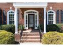 Elegant front entryway with brick steps, white columns and beautifully landscaped bushes at 3230 Munsey Ct, Cumming, GA 30041