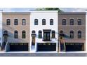 Elegant townhouses with mixed brick exteriors, large windows, private balconies, and integrated garage spaces at 345 Sugarview Rd, Sugar Hill, GA 30518