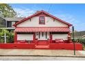 Charming home with white and red exterior, awning, landscaped front yard, and inviting entryway at 814 Welch Sw St, Atlanta, GA 30310