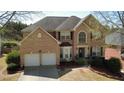 Lovely two-story brick home showcasing a two-car garage, lush landscaping, and an inviting front entrance at 2688 Autumn Ridge Ln, Lawrenceville, GA 30044