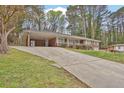 Lovely single-story brick home featuring a covered carport, a long driveway, and mature trees at 3441 Palace Ct, Tucker, GA 30084