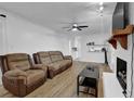 Bright living room with hardwood floors, a ceiling fan, a brick fireplace, and ample seating at 3441 Palace Ct, Tucker, GA 30084