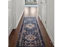 Hallway featuring hardwood floors, a patterned blue runner, and bright white walls at 7083 Gladstone Cir, Stonecrest, GA 30038