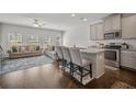 Modern kitchen with stainless appliances, granite counters, and island seating, adjacent to a comfortable living area at 7083 Gladstone Cir, Stonecrest, GA 30038